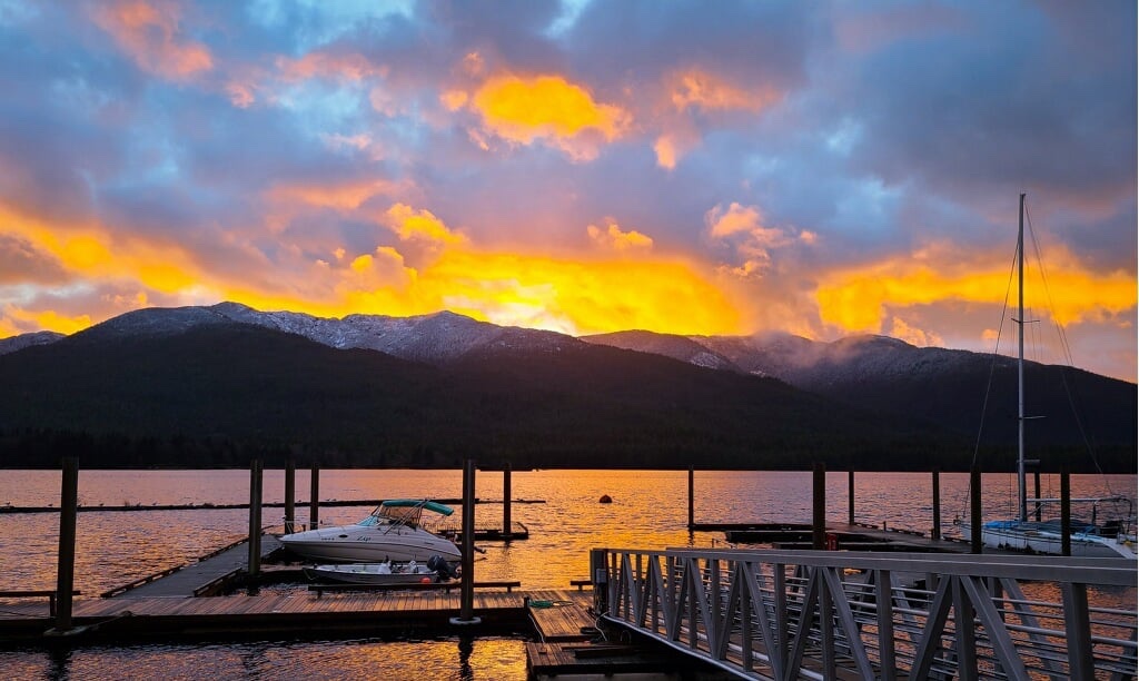 Golden sunset over the marina with boats and mountains